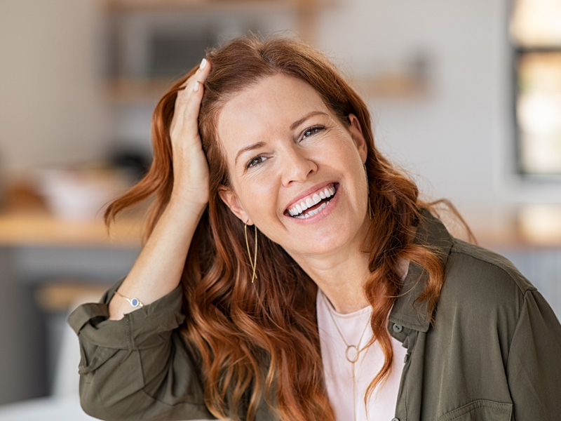 Woman smiling after her successful female hair transplant treatment in Edmonton and Sherwood Park.
